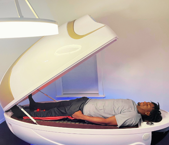 Client relaxing in a Cocoon Wellness Pod at Heat and Wellness Spa in Ripley, MS during an infrared heat therapy session designed to promote deep relaxation, improve circulation, support detoxification, and reduce muscle tension.