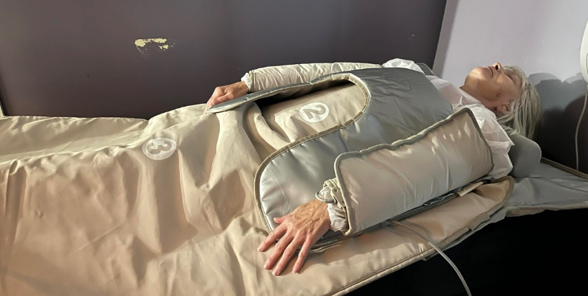 Client receiving a pressotherapy session at Heat and Wellness Spa in Ripley, MS using compression therapy sleeves to support circulation, lymphatic drainage, muscle recovery, and relaxation.